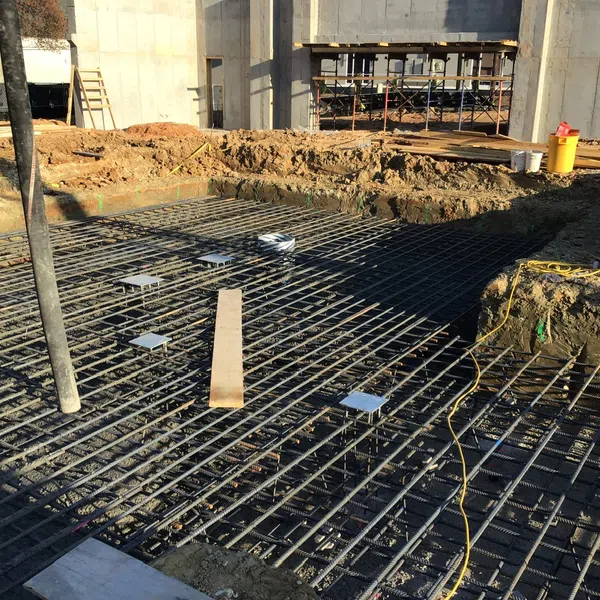 Construction site with steel rebar grid ready for concrete foundation pouring at a building project.