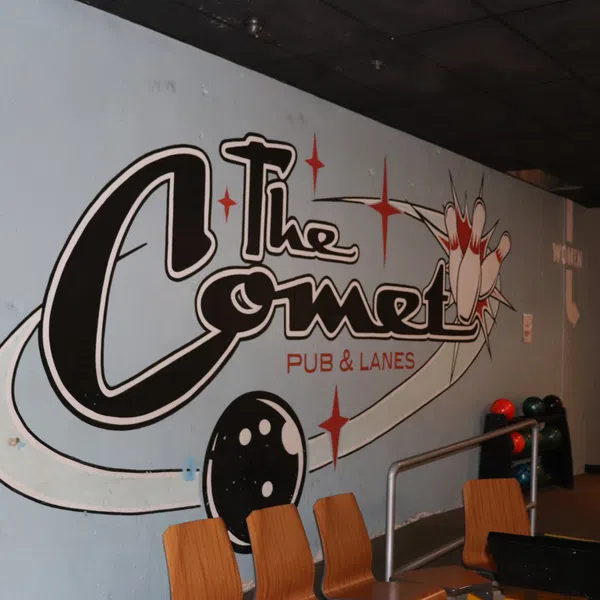 Wall mural of The Comet Pub & Lanes with bowling ball, pins, and stars at a bowling alley interior.