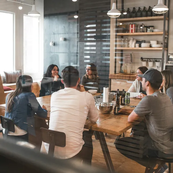 Group of young professionals having a meeting around a wooden table in a modern office space.