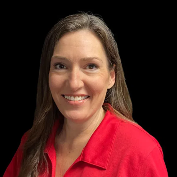 Smiling woman with long brown hair wearing a red polo shirt with a circular embroidered logo on black background
