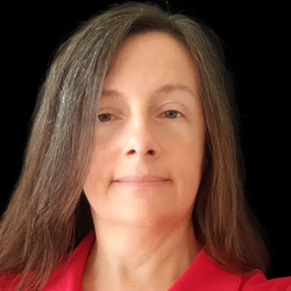 Woman with long brown hair wearing a red collared shirt with a black background.