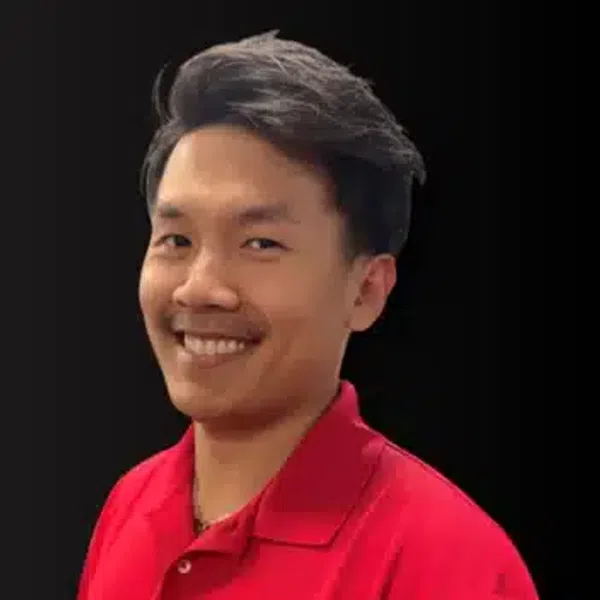 Smiling man in red polo shirt with embroidered logo on black background