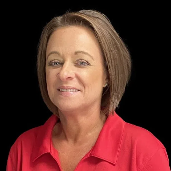 Woman with short hair wearing a red polo shirt with a round logo on black background
