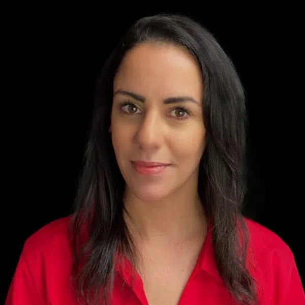 Woman with dark hair wearing a red shirt with a logo on a black background