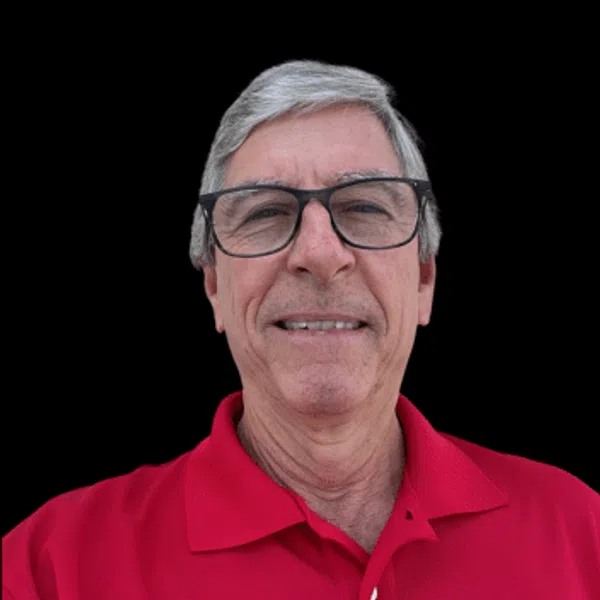 Older man with gray hair and glasses wearing a red Polo shirt with a Coastwatching logo on black background