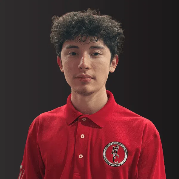 Young man with curly hair wearing a red polo shirt with a circular logo on a dark background