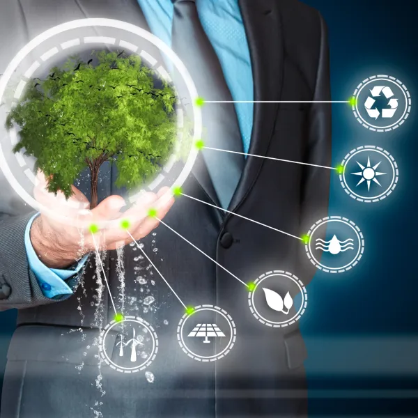 Businessman holding a digital green tree surrounded by eco-friendly icons representing renewable energy and sustainability.