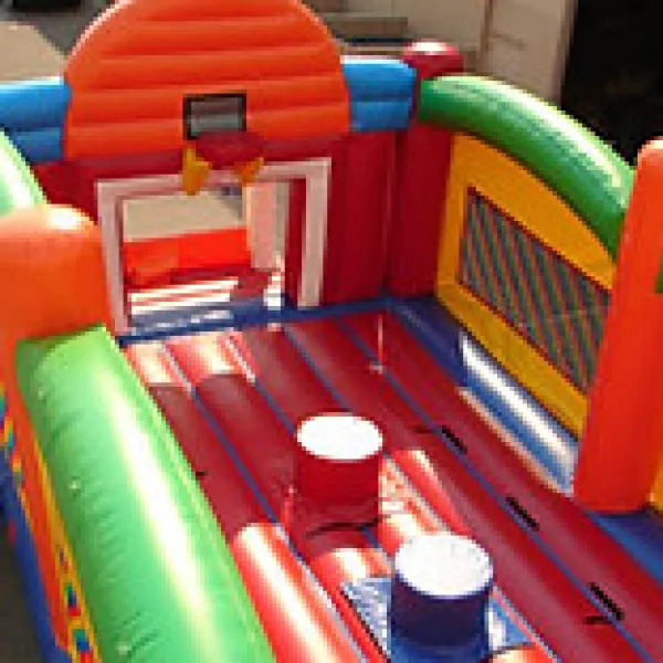 Colorful inflatable basketball court with hoops and padded obstacles on a sunny day