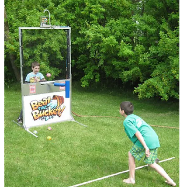 Two boys playing outdoor ball toss game called Beat the Bucket in grassy backyard with green trees