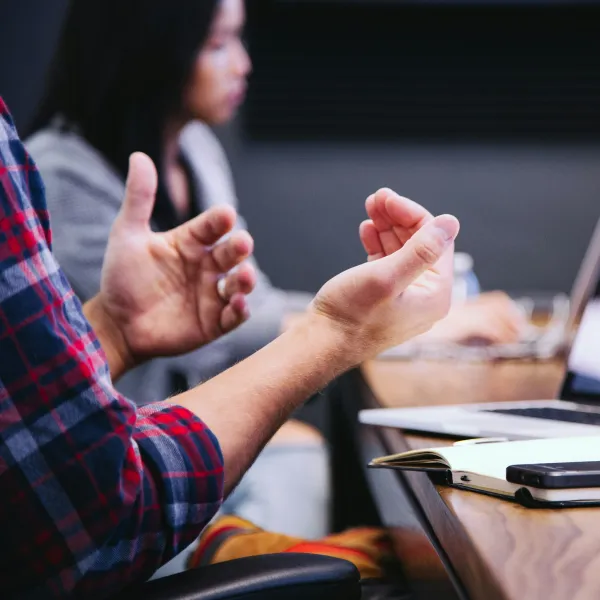 a person pointing at a laptop