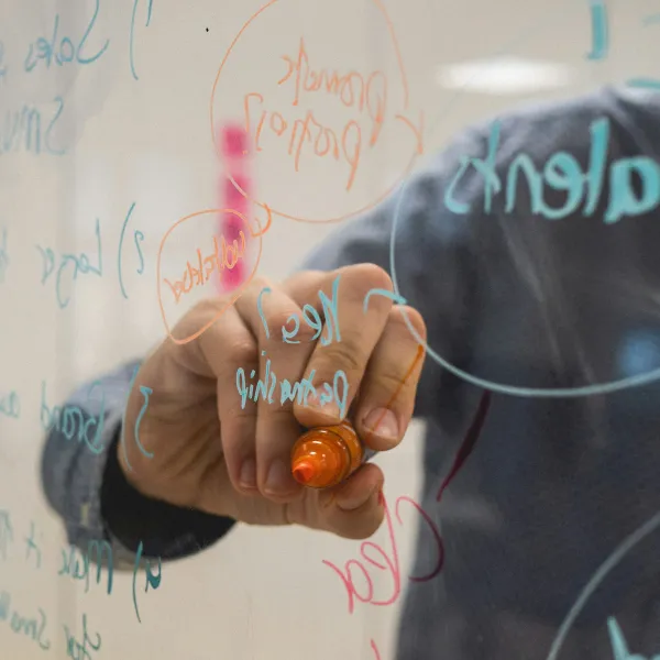 a person writing on a whiteboard