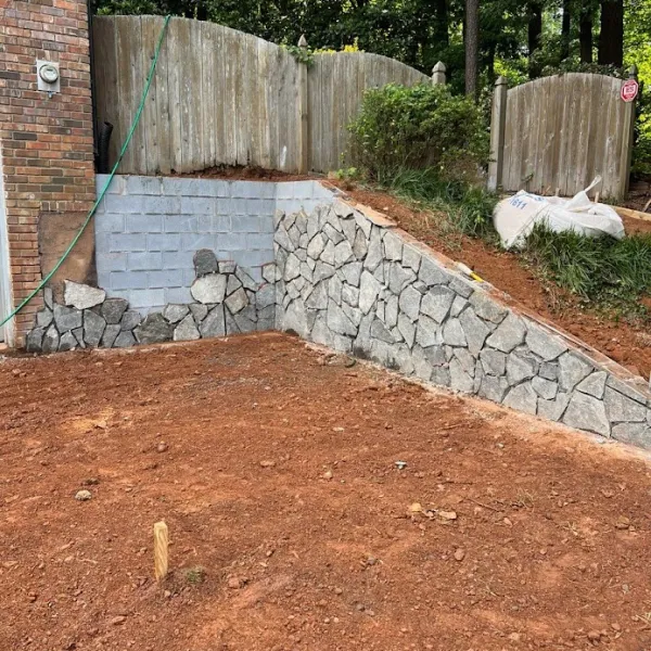 a wall with a fence and a brick wall