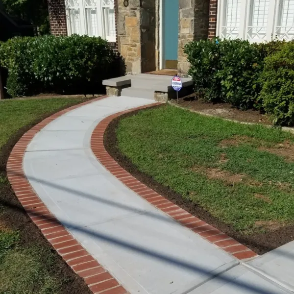 a brick walkway with a bench and a sign on it