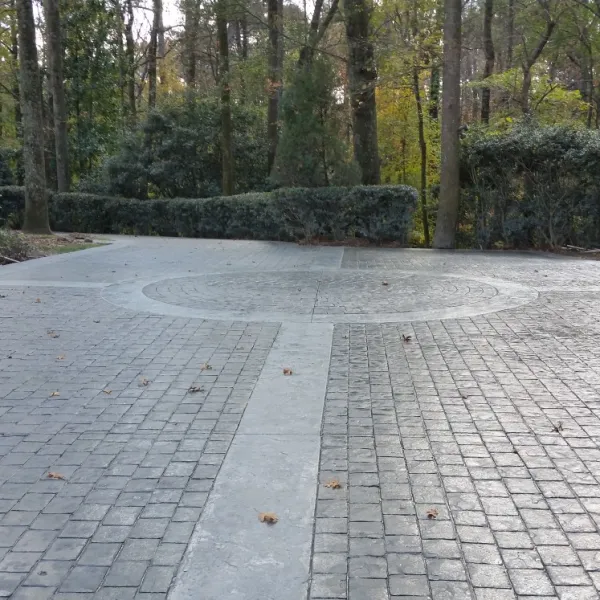 a brick walkway with trees and bushes