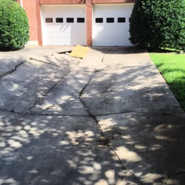 a driveway with a house in the background