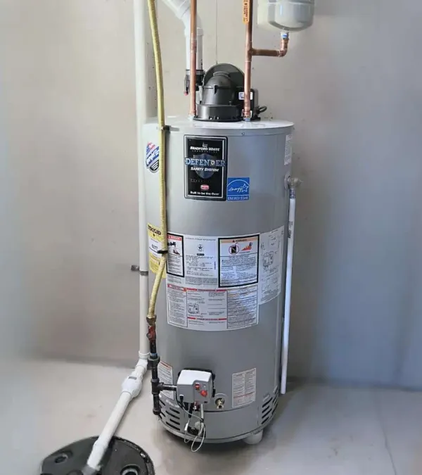 Bradford White Defender Safety System water heater with piping installed against a white wall indoors.