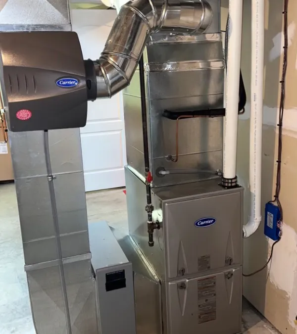 Residential Carrier HVAC furnace system with ductwork and vent pipes installed in basement