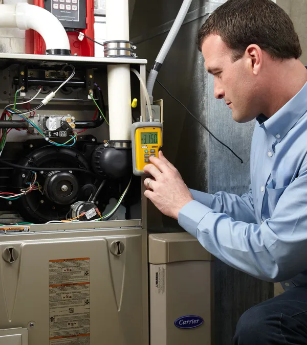 Technician assessing a furnace's performance with a multimeter in a well-lit utility room.