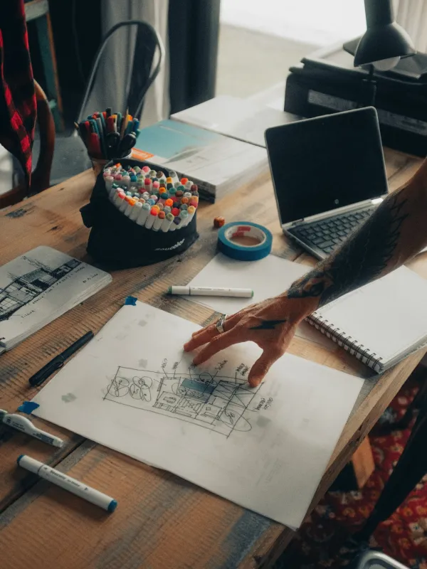 a desk with a laptop and a pen on it