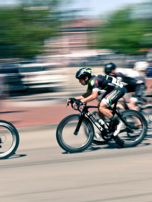 Cyclists in helmets racing at high speed in an outdoor urban road cycling competition