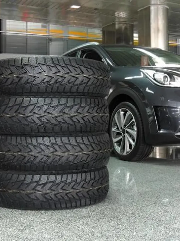 a car with a large stack of tires in front of it
