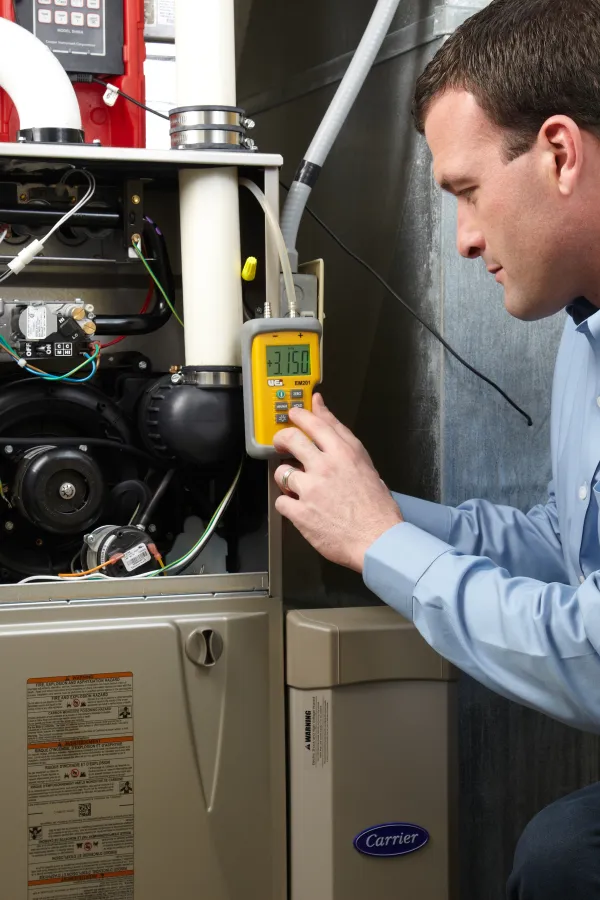 Technician examining a heating system, showcasing HVAC maintenance and troubleshooting.