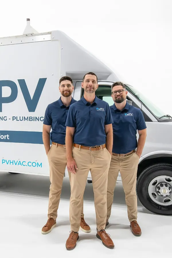 Three uniformed HVAC technicians standing confidently beside a PV heating, cooling, and plumbing service van