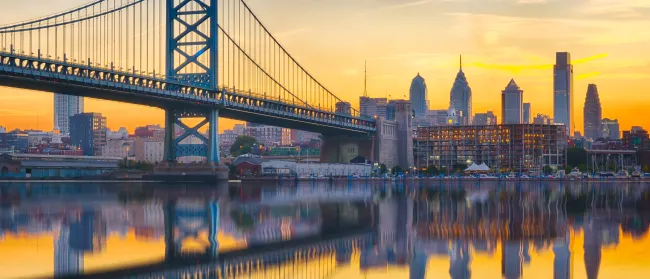 a bridge over water with a city in the background