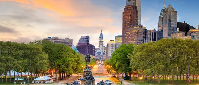 a park with a fountain and tall buildings in the background