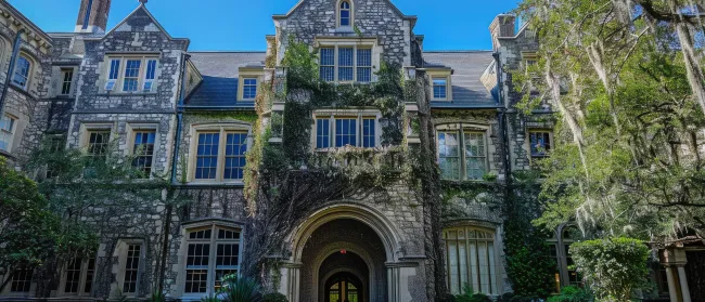 a large stone building with a courtyard with Joslyn Castle in the background