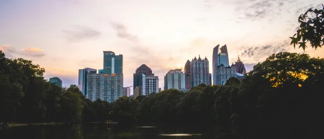 a city skyline with trees and water