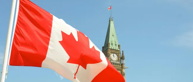 a flag flying in front of a clock tower