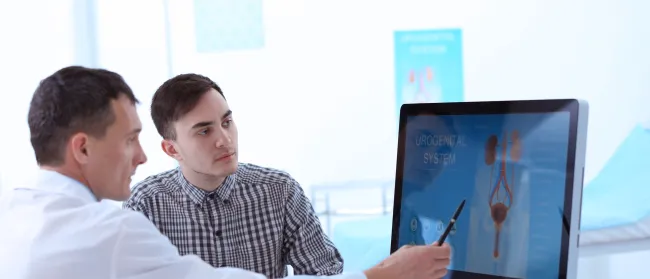 a man showing another man something on the computer