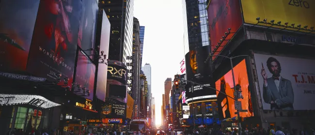 a busy city street with Times Square in the background