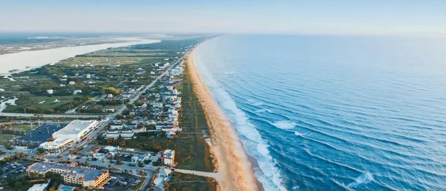 a beach with buildings and water