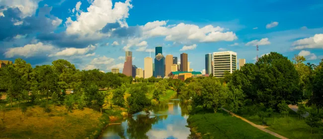 a river with trees and buildings in the background