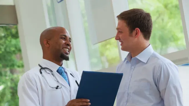Doctor discussing medical results with a smiling patient in a bright office setting