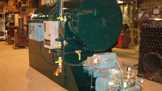 Industrial boiler system with control panel and gauges in a large factory setting.