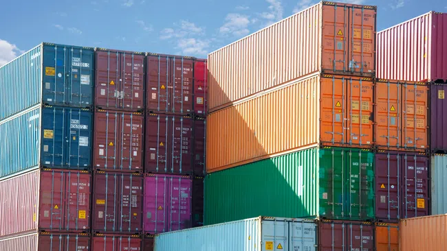 a group of containers stacked together with Museo de Arte Contemporáneo de Castilla y León in the background