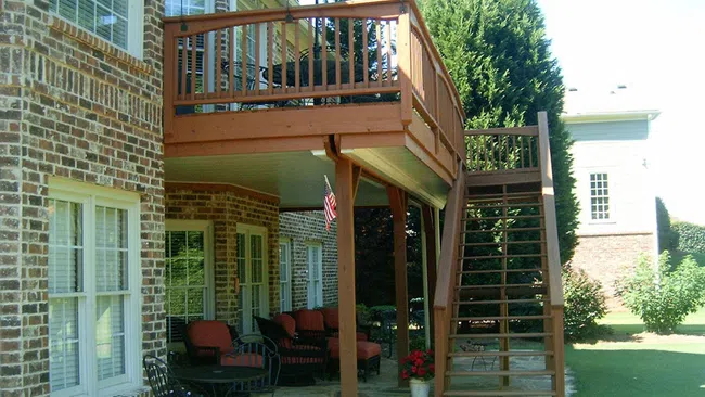 a deck with a chair and umbrella