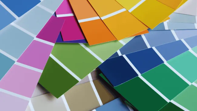 Color swatches fanned out showing various shades of blue, green, pink, orange, and yellow for paint selection.