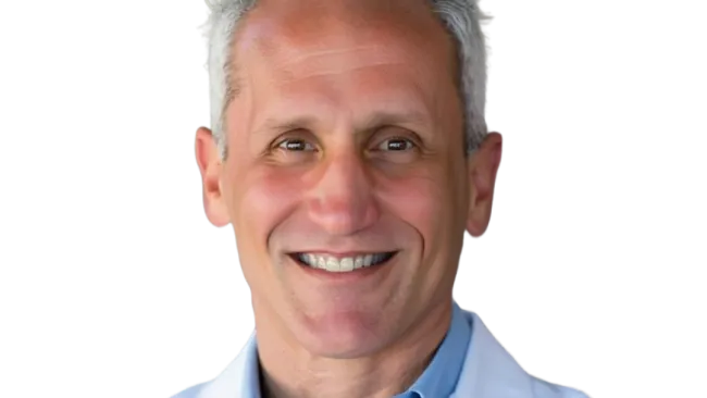 Smiling middle-aged male doctor with gray hair wearing a white lab coat and blue shirt