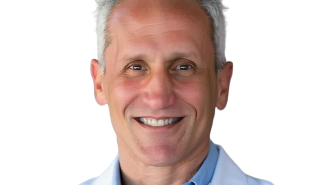 Smiling middle-aged male doctor with gray hair wearing a white lab coat and blue shirt