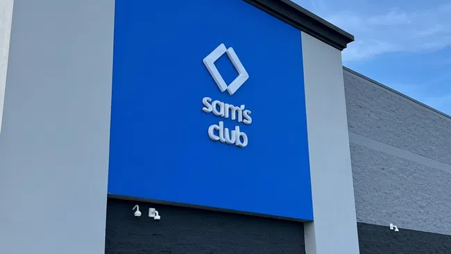 Exterior of a Sam's Club store with a large blue sign and clear sky background