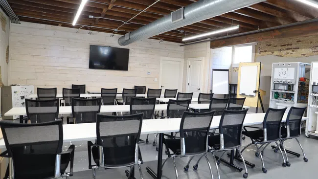 a room with a large group of chairs and a tv on the wall