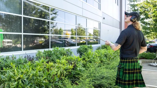 a person in a kilt standing outside a building