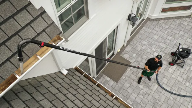 a person cleaning a gutter