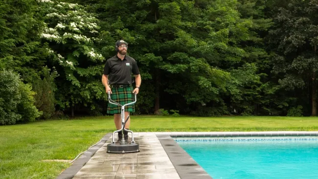 a man standing on a platform near a pool