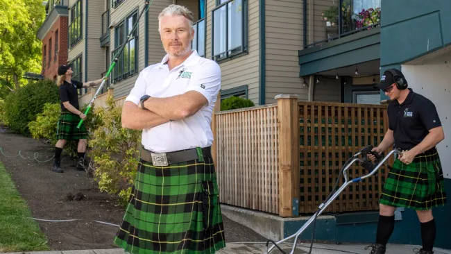 a person in a kilt standing in front of a building