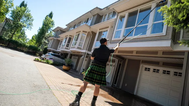 a man wearing a kilt and cleaning windows